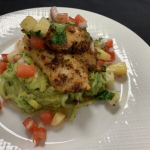 Blackened Grouper Filet served over Zoodles with Avocado Pesto, and Pineapple Citrus Salsa