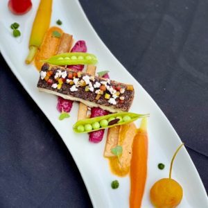 Harissa Crusted Red Fish, Sweet and Sour Root Vegetables, Pan Seared Yukon Golds, Purple Potato Puree, Foamed Ancho-Tomato Coulis, English Peas and Bell Pepper-Popped Sorghum Relish