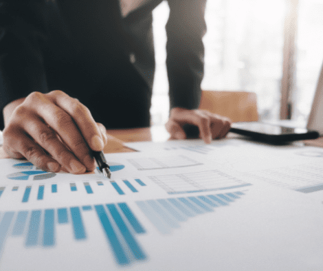 Man points at chart on top of table with a pen.